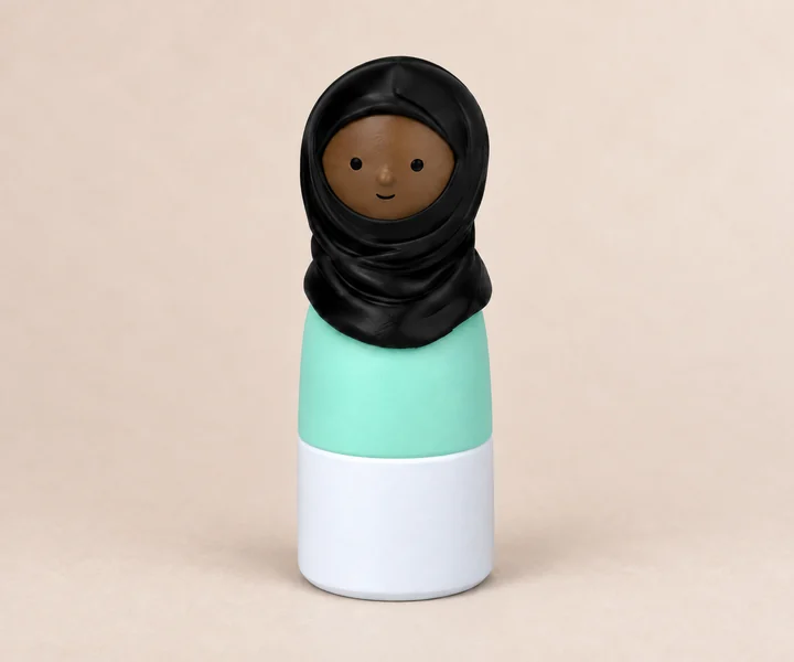 3D-printed figure with a brown face, a black headscarf, a mint-green top and a white base